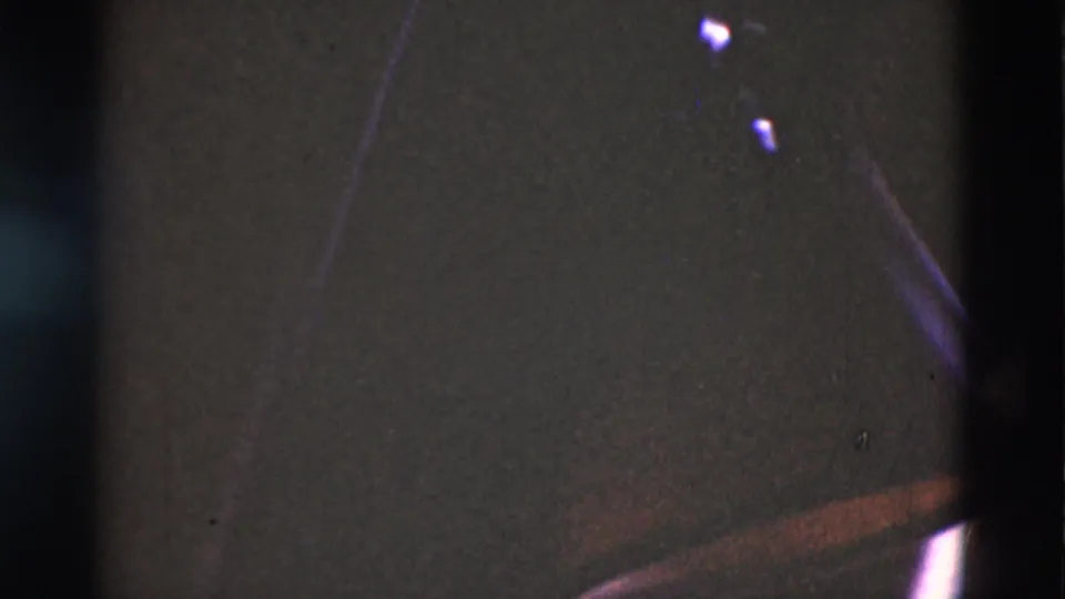 End frame from the 1975 Portugal 8mm clip showing mostly dark exposure, scratches, and film artifacts.