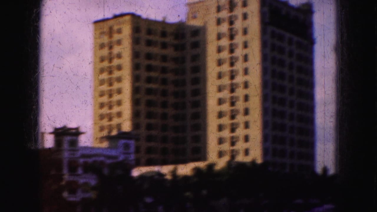Tall waterfront buildings seen through soft 8mm film grain and dark frame edges.