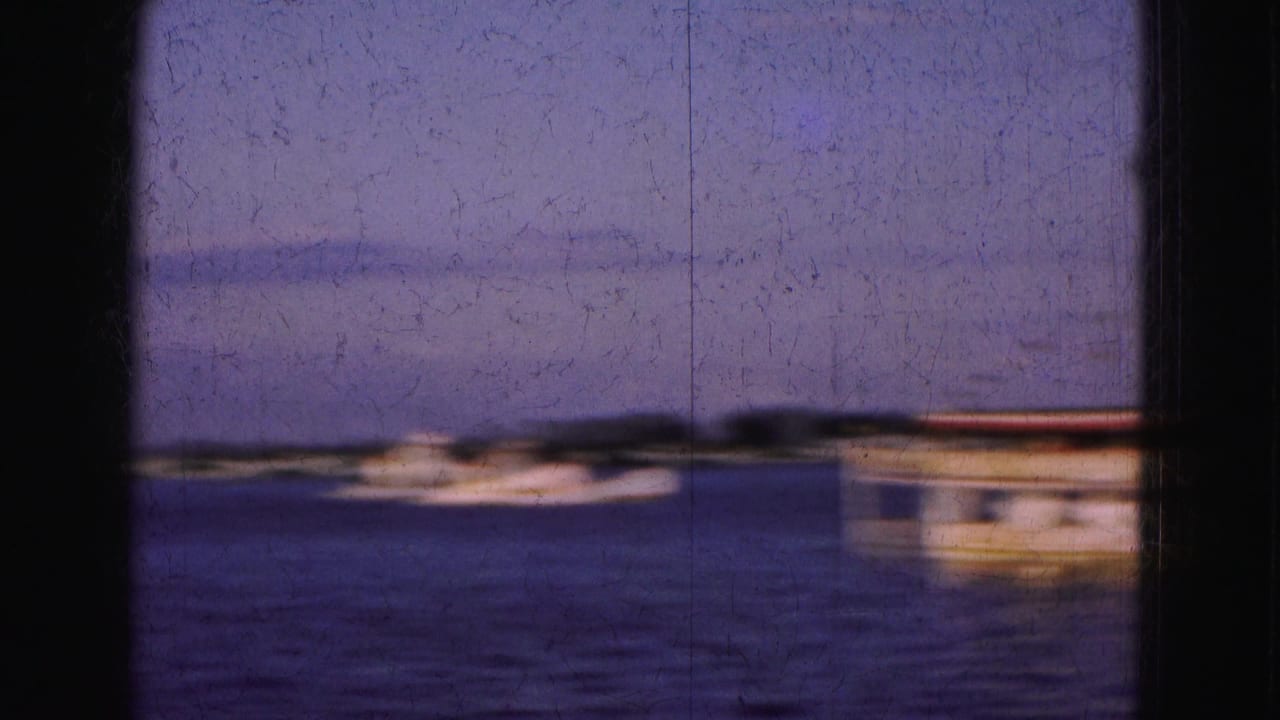 Small white boat on the water with part of a larger boat at the right edge.
