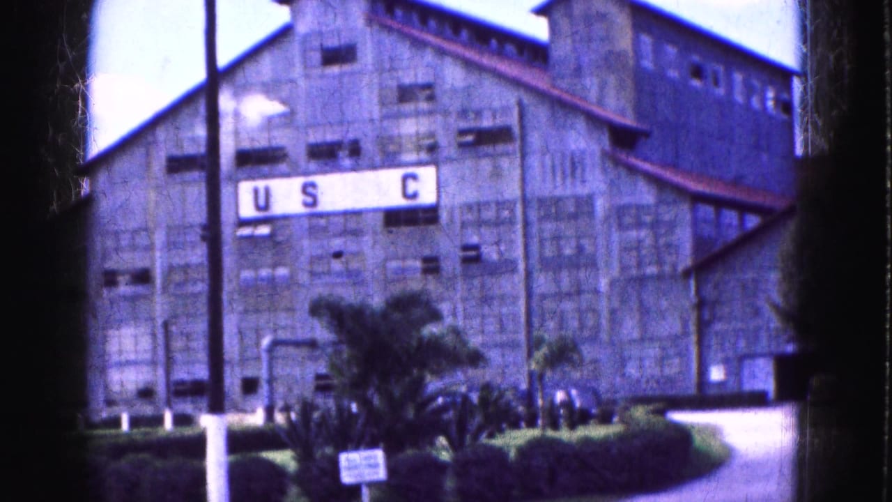 Large industrial building with USC lettering, palm landscaping, and a paved foreground.