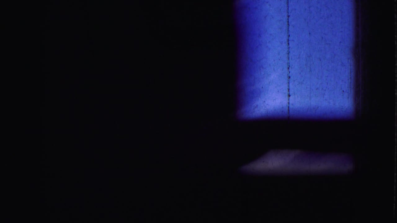 Mostly dark frame with a blue rectangular light area near the upper right.