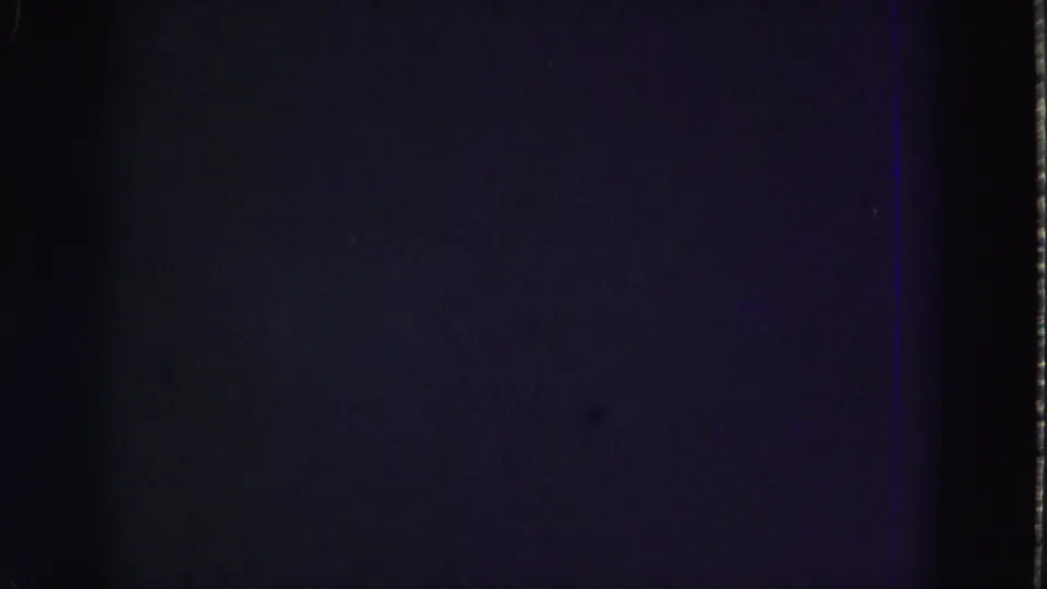 Dark underexposed 8mm frame with faint color shift and a vertical film edge from the supplied 1975 Everglades clip.