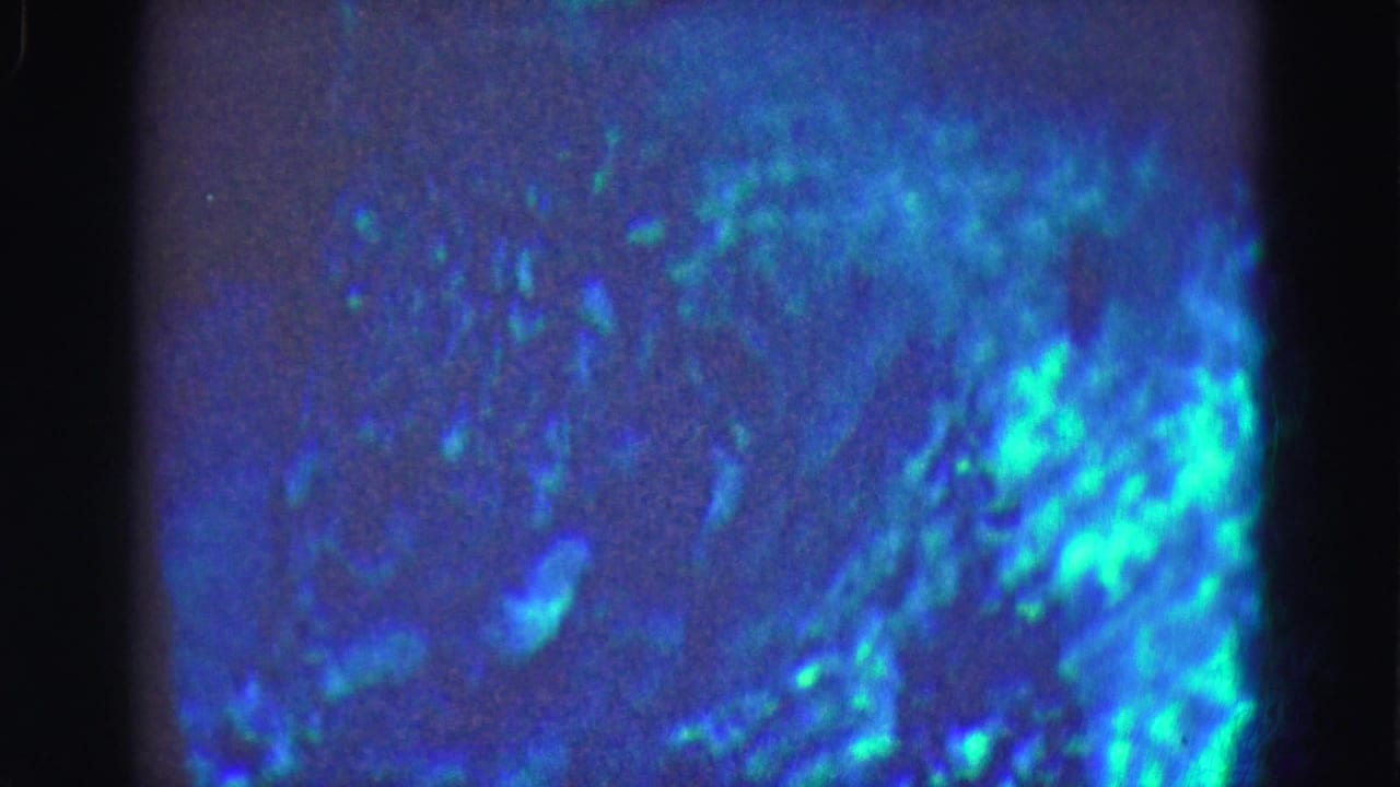 1975 8mm Florida Everglades footage with blue underwater haze, bright cyan patches, grain, and visible frame edge.