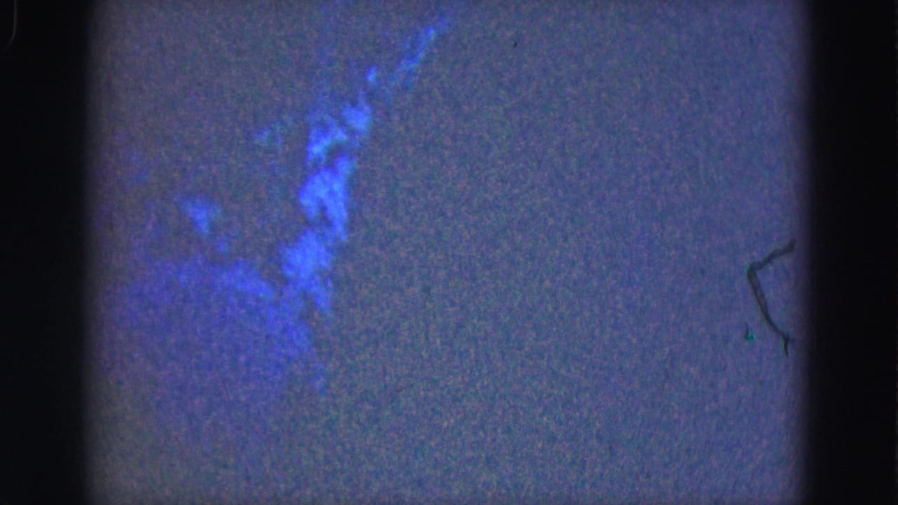 Blue underwater view with a darker aquatic shape near the upper center.