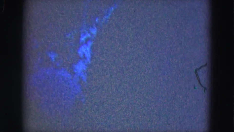 1975 Florida Everglades underwater frame with a dark fish-like shape against grainy blue water.
