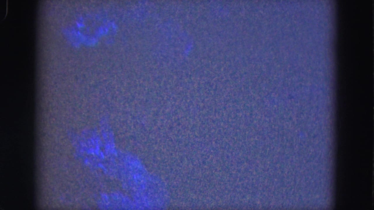Dark textured frame with blue cloud-like shapes and a central black film divider.
