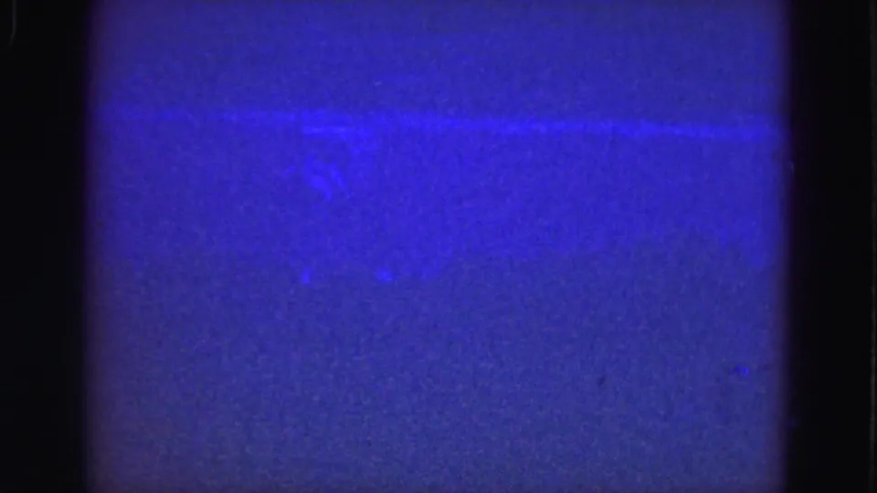 1975 8mm underwater view with a pale horizontal light distortion across blue water and visible film texture.