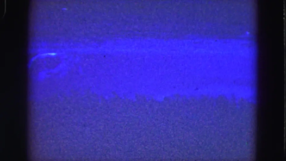 1975 Florida Everglades 8mm frame dominated by blue-purple exposure, grain, and dark film-gate edges, with no identifiable subject visible.