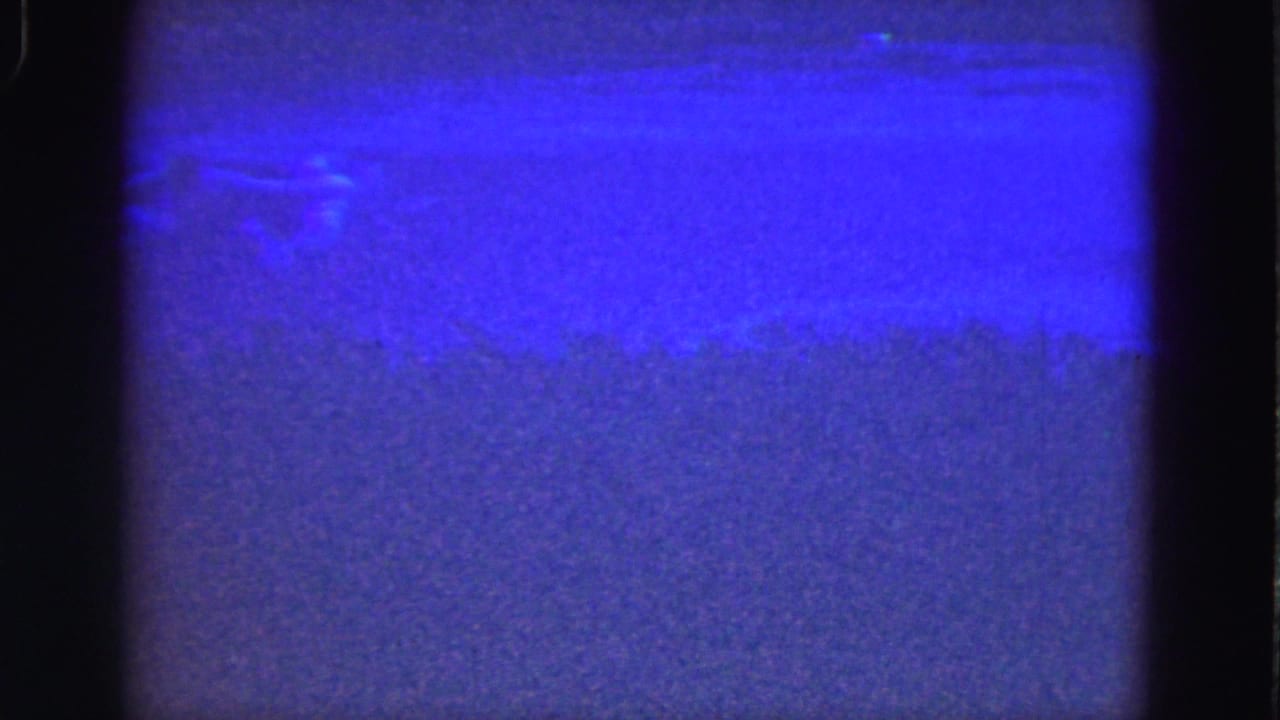 Abstract blue 8mm frame with purple grain, dark side borders, and faint scratches.