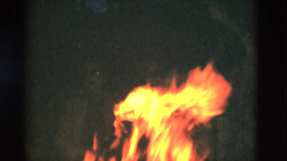 1975 Somerset, Kentucky frame with a bright orange fire illuminating a dark wooded scene.