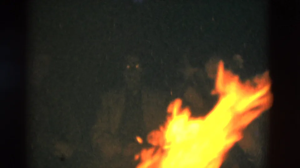 1975 Somerset, Kentucky 8mm frame showing bright campfire flames in a dark nighttime setting.