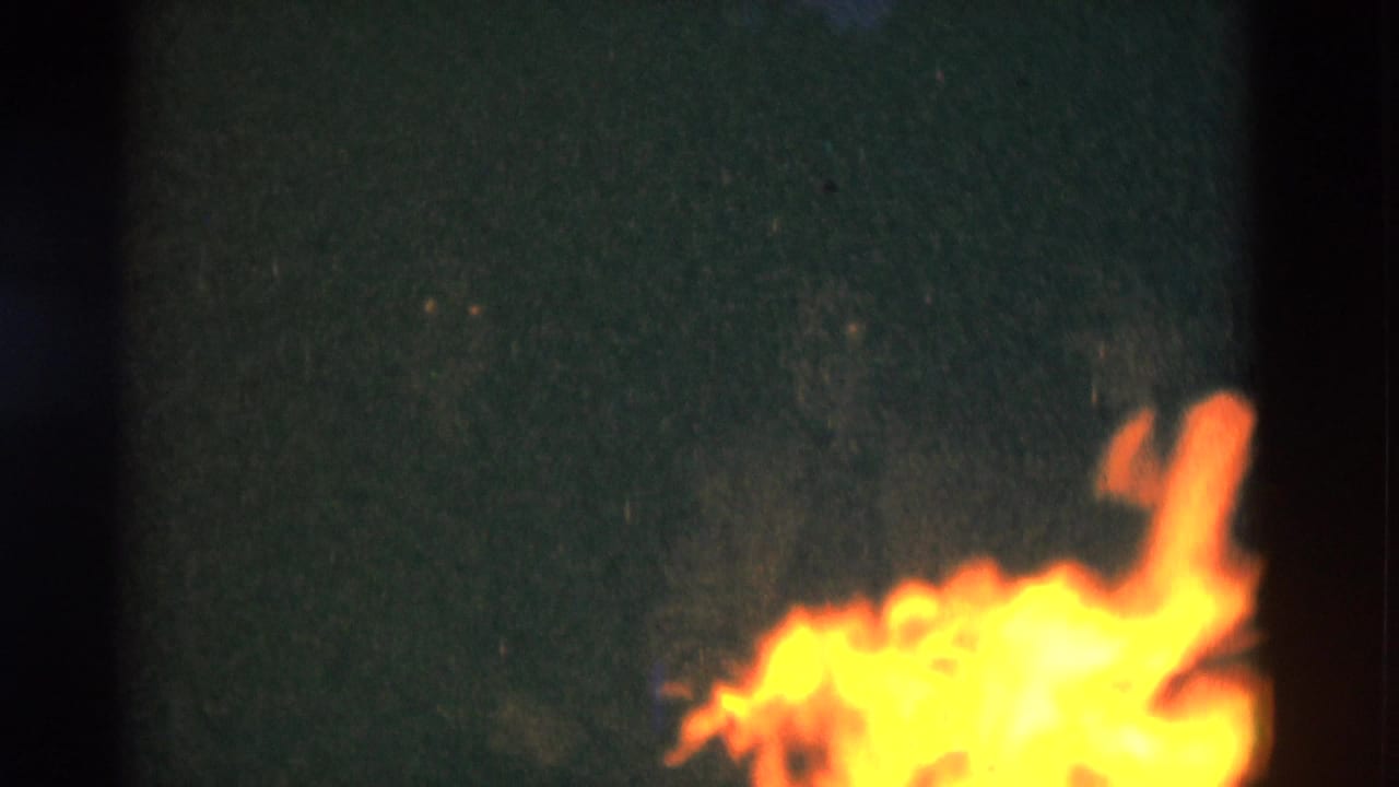 8mm home-movie frame from Somerset, Kentucky showing firelight and dark surroundings at night.
