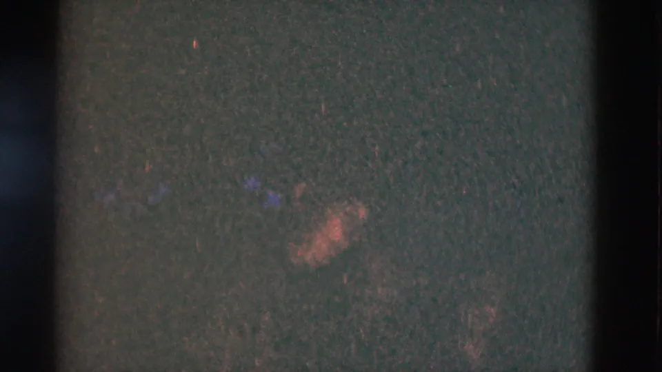1975 8mm Somerset, Kentucky footage shows a very dark nighttime frame with grain, faint warm light, and film-strip shading.
