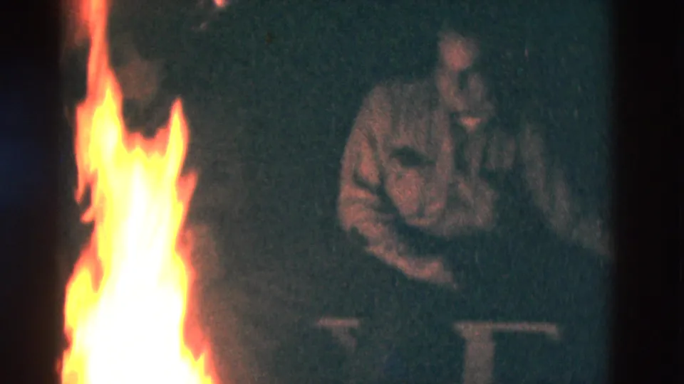 A bright campfire illuminates seated older men in 1975 Somerset, Kentucky 8mm nighttime footage.