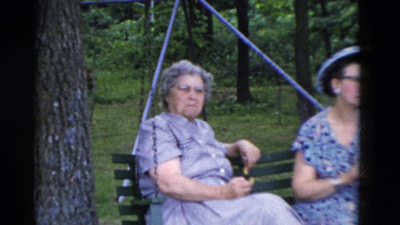A 1975 Somerset, Kentucky park shot shows two women on a green bench, one centered and one partly blurred near the frame edge.
