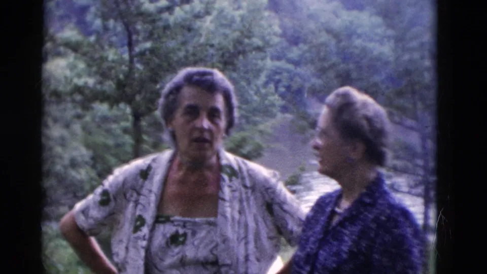 Two adult women in patterned clothing stand in a wooded Somerset, Kentucky outdoor setting in a 1975 8mm home movie frame.