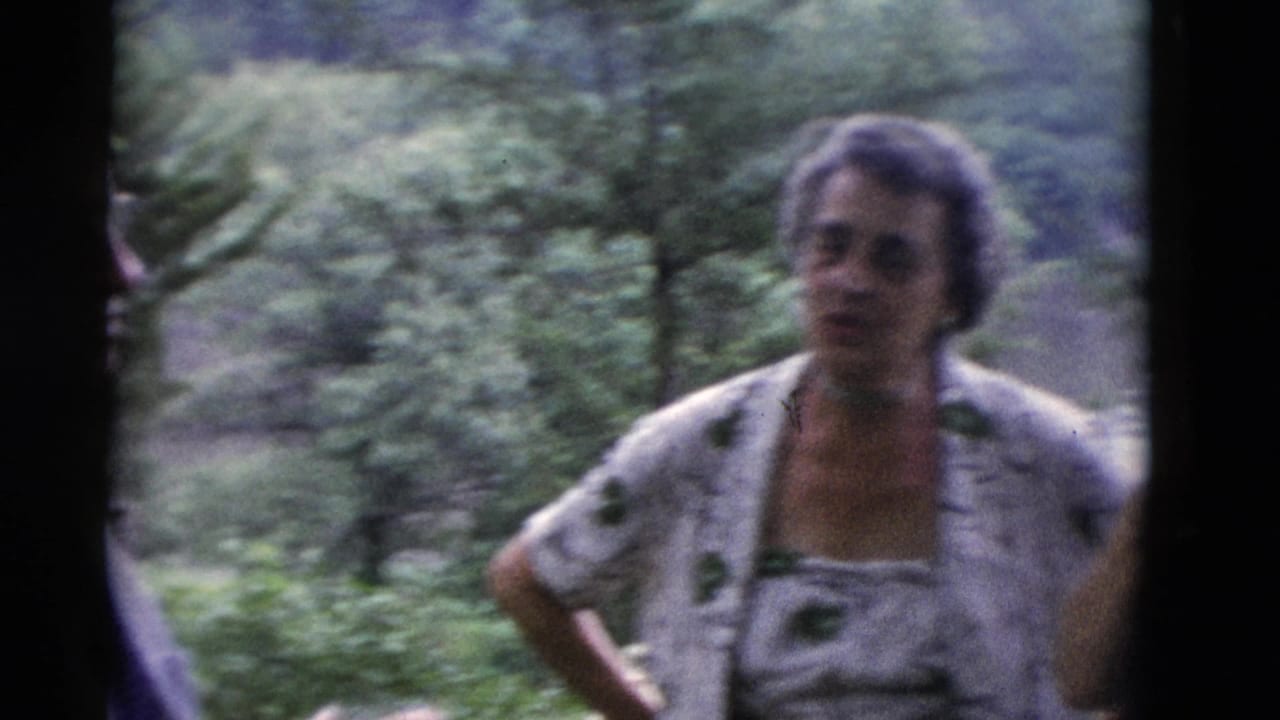 In Somerset, Kentucky 1975 home-movie footage, an older woman stands in a wooded setting while another adult is partly visible.
