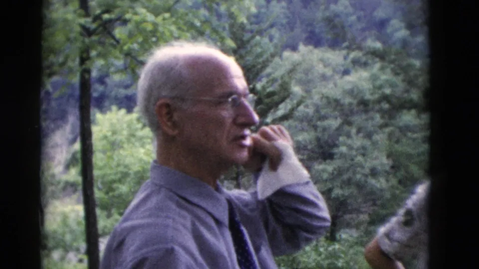 The older man appears in close profile, raising a hand near his face during a 1975 outdoor gathering in Somerset, Kentucky.