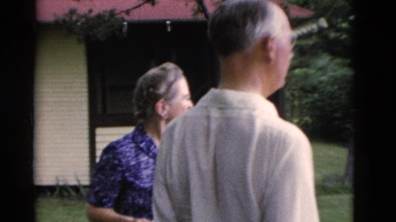 In 1975 Somerset, Kentucky home-movie footage, an older man stands with his back to camera while a woman is partly visible near a house.