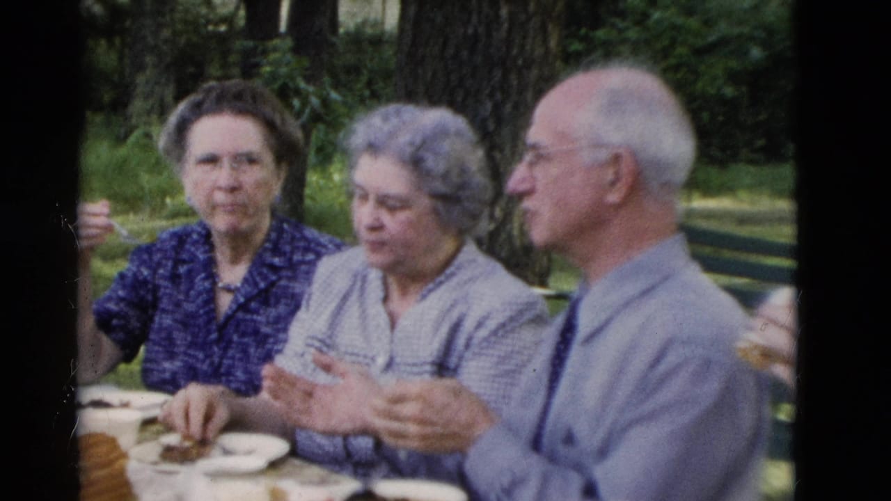 1975 8mm home-movie frame from Somerset, Kentucky showing two older women and an older man seated at an outdoor picnic table.