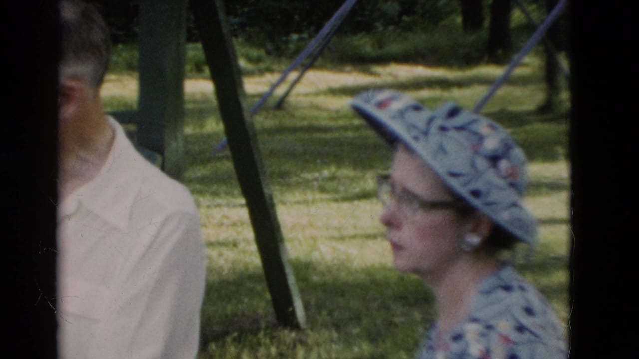 An older woman in a patterned sunhat and glasses sits beside a man in a pale shirt in the supplied 1975 Somerset, Kentucky park scene.