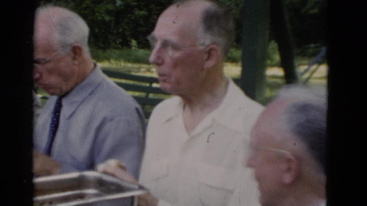 Older men in collared shirts sit at a park meal table in Somerset, Kentucky, filmed on 8mm in 1975.