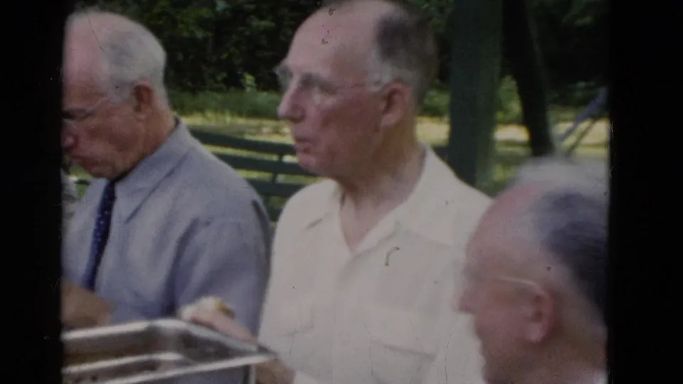 Older men in collared shirts sit at a park meal table in Somerset, Kentucky, filmed on 8mm in 1975.