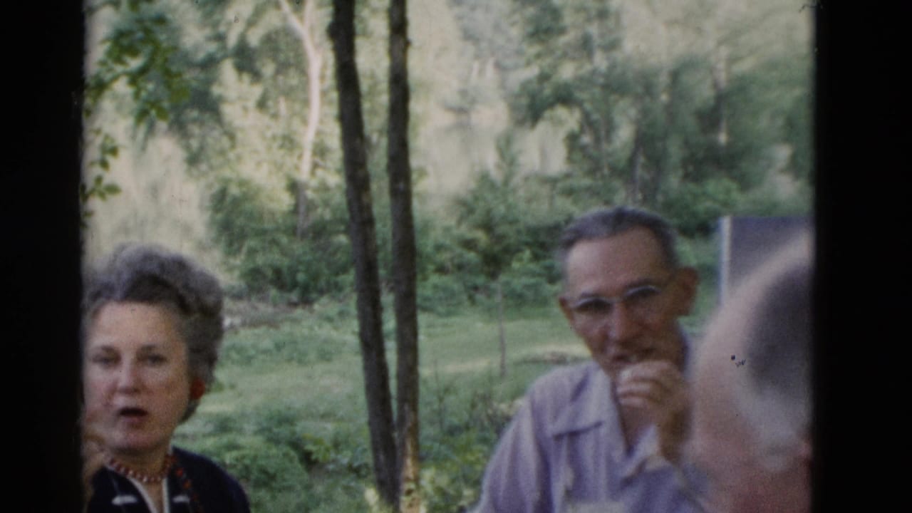 Older woman with curled gray hair and older man with glasses sit outdoors in Somerset, Kentucky home-movie footage from 1975.