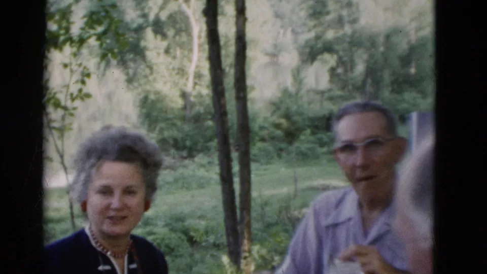 An older woman smiles near an older man in glasses during a 1975 outdoor gathering in Somerset, Kentucky.