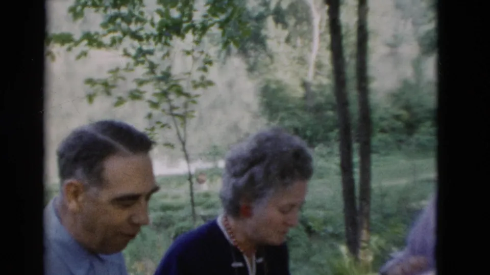A man in profile sits beside an older woman at a 1975 outdoor social gathering in Somerset, Kentucky.