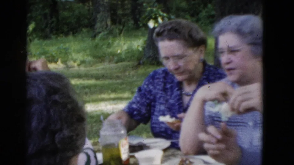 Somerset, Kentucky home-movie frame from 1975 with two older women partly visible at a picnic table in a grassy park setting.