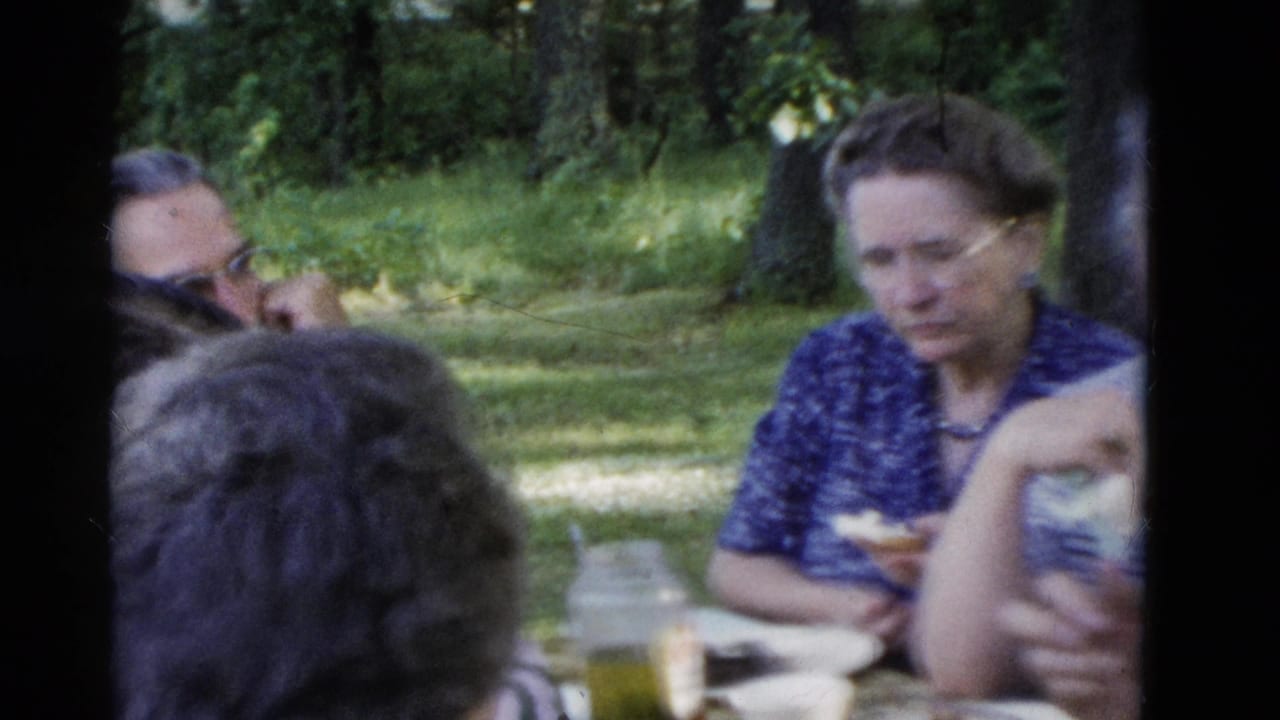 Older adults at a Somerset, Kentucky picnic table in 1975, eating and sitting in a wooded grassy area.