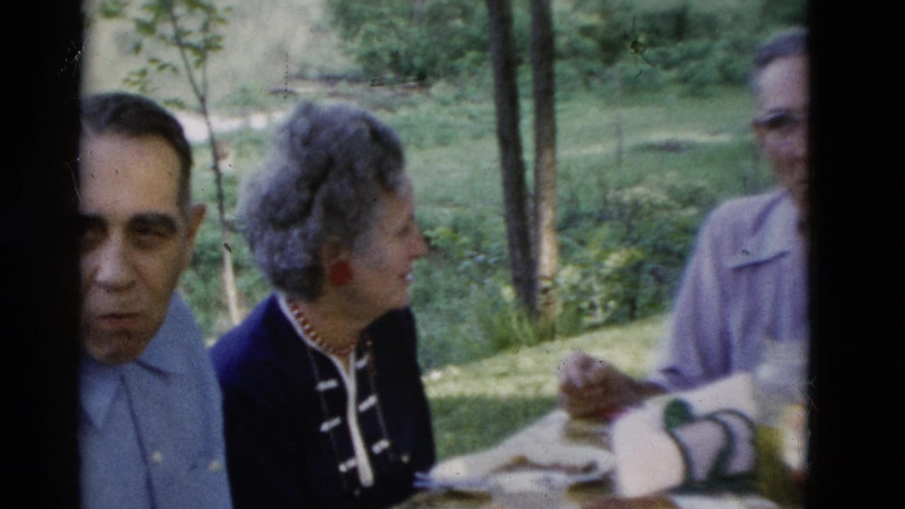 1975 Somerset, Kentucky 8mm frame of older adults seated at an outdoor table during a casual meal.
