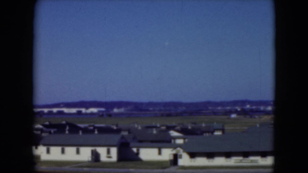 1975 Middletown, Pennsylvania view of low institutional buildings, open grass, and distant development under a clear blue sky.