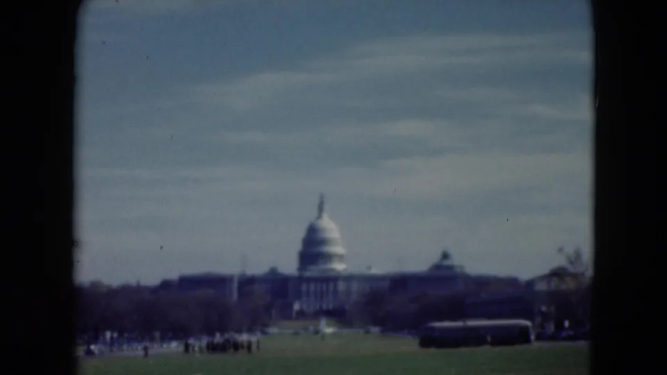 Washington, D.C. Capitol view from 1975 home-movie footage, with a bus in the lower right and small visitors near the lawn.