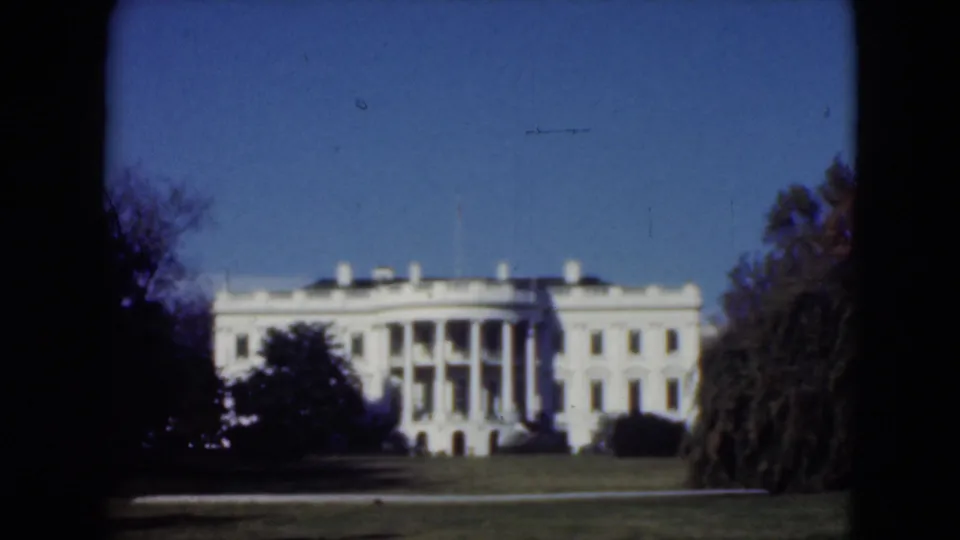 1975 8mm footage cataloged to Middletown, Pennsylvania, showing a distant white classical building framed by trees and dark film borders.