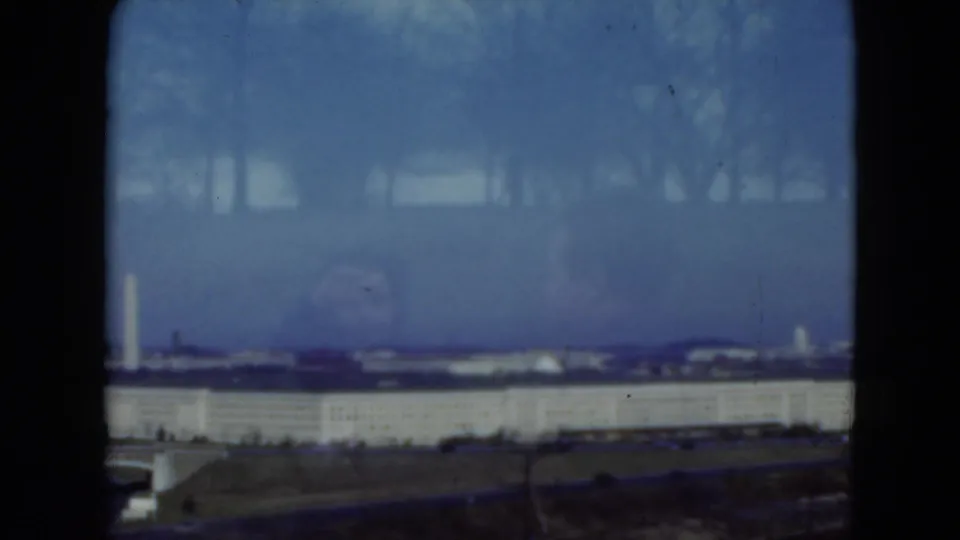 1975 Middletown, Pennsylvania view with a tall white landmark-like form beyond a pale building and open grass.