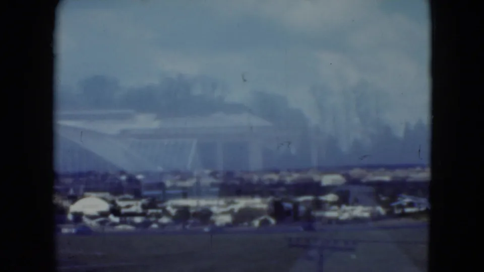 Final 1975 Middletown, Pennsylvania frame showing a hazy suburban edge with open ground, roads, low buildings, and distant trees.