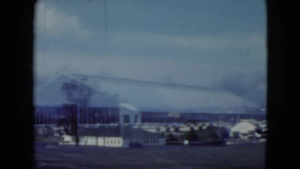 1975 Middletown racetrack-area view with arched roof, glass-like facade, parked cars, and heavy dark 8mm frame border.