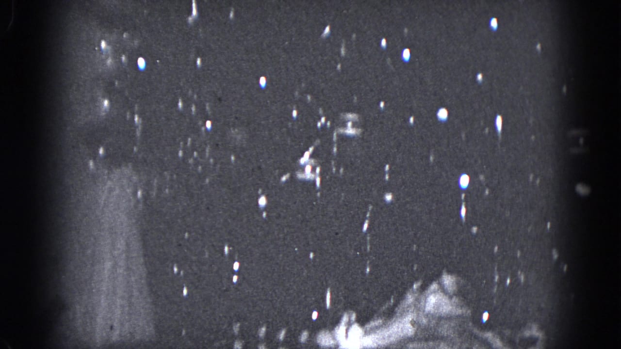 1975 Middletown, Pennsylvania 8mm frame showing a small lit tabletop Christmas tree in a dim holiday interior.