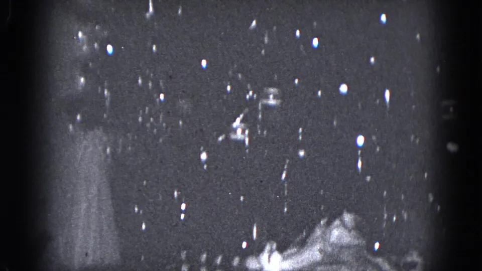 1975 Middletown, Pennsylvania 8mm frame showing a small lit tabletop Christmas tree in a dim holiday interior.