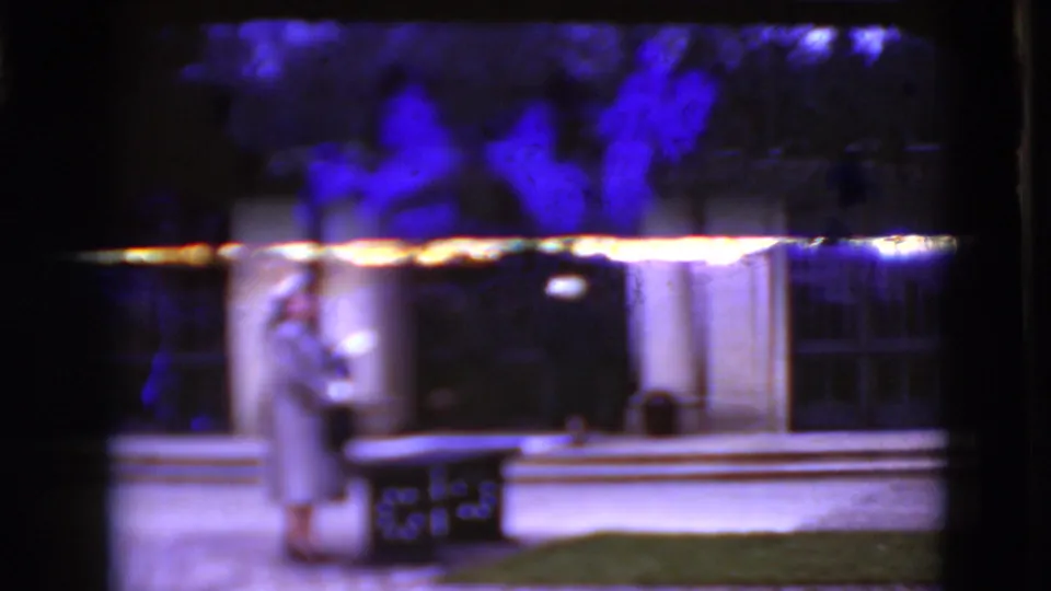 1975 8mm frame in Middletown, Pennsylvania, showing part of a classical building exterior with columns, arched windows, lawn and railing.