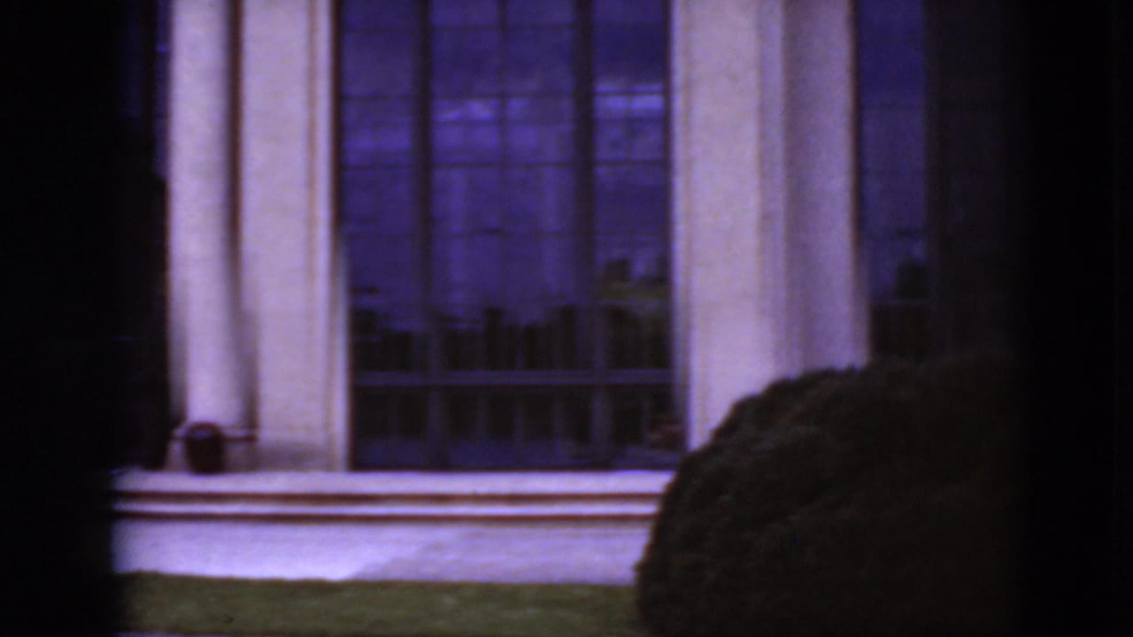Tall windows and columns with a dark vertical foreground obstruction.