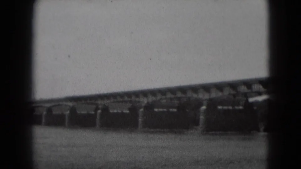 1975 8mm view in Middletown, Pennsylvania, showing a steel truss bridge and stone piers above a wide river.