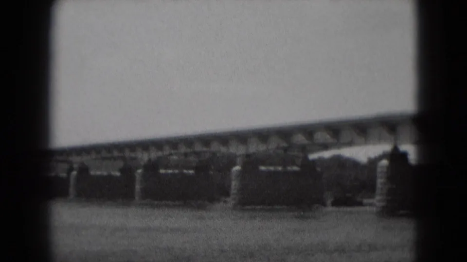The bridge continues across the frame, with repeating stone piers and a calm river below in the Pennsylvania home-movie footage.