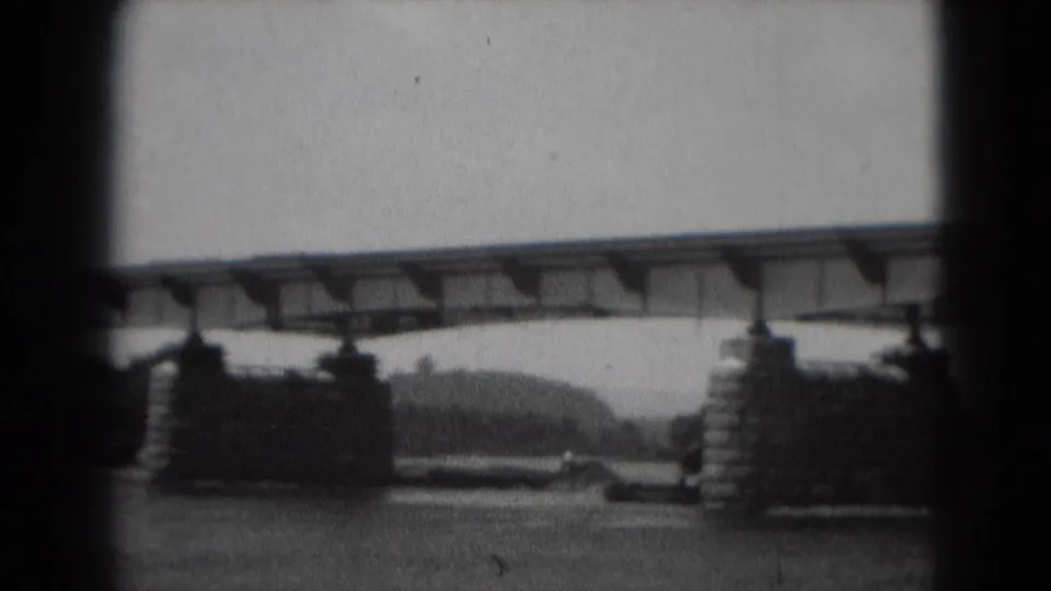 1975 Middletown, Pennsylvania 8mm frame showing a metal bridge crossing a river on large piers, with wooded banks beyond.