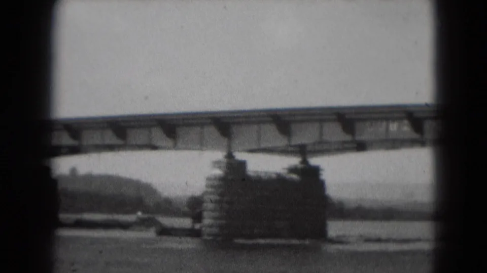 Black-and-white 8mm view of the Middletown bridge crossing the river, with piers and a wooded shoreline in the background.