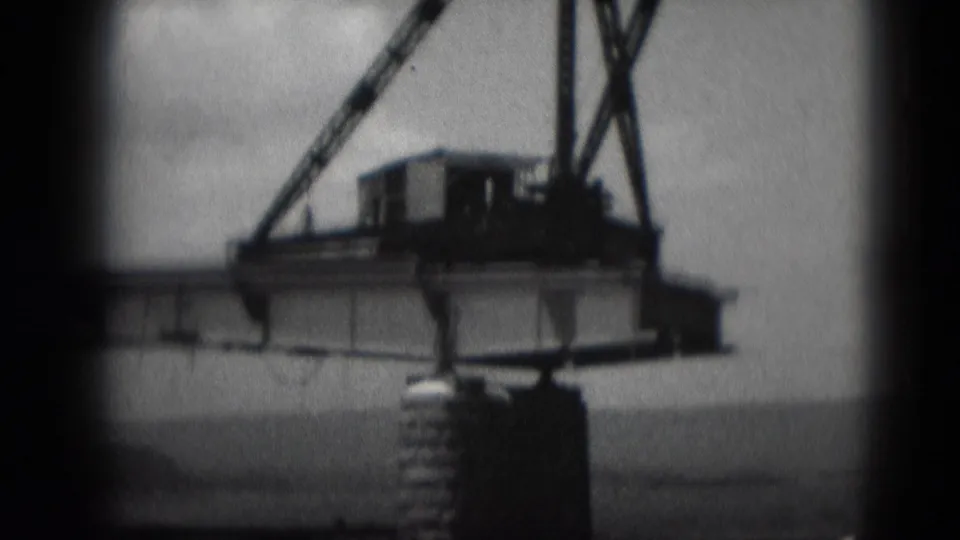 1975 Middletown, Pennsylvania 8mm view of a bridge over water, with heavy equipment on the span and a concrete support pier below.