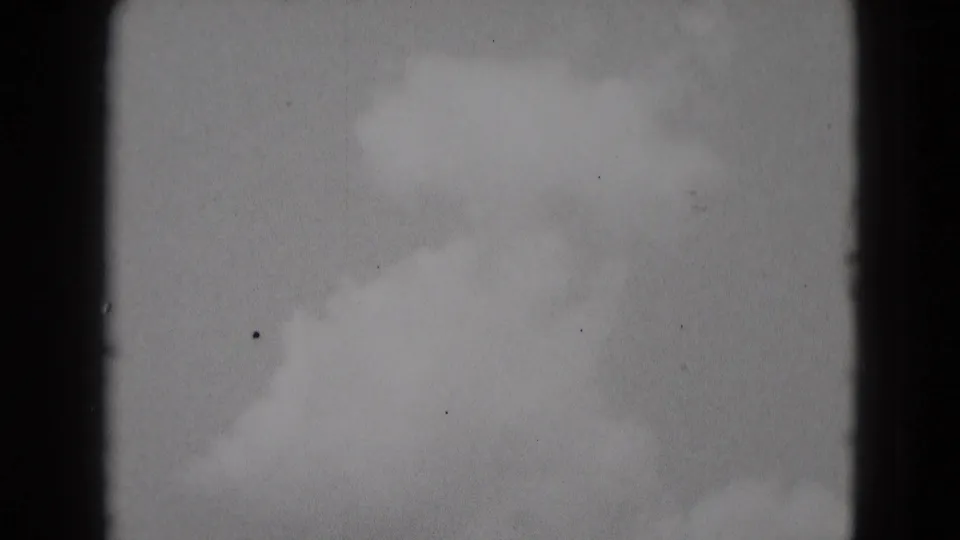 Soft 8mm end frame showing cloudy sky, dark film edge, and visible dust or speckling from the scan.