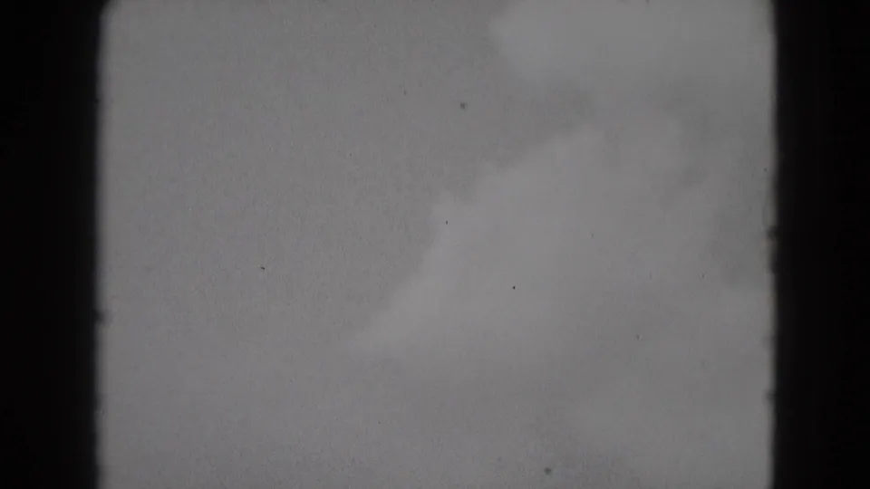 1975 Middletown home-movie frame showing a pale cloudy sky with visible 8mm frame edges and film grain.